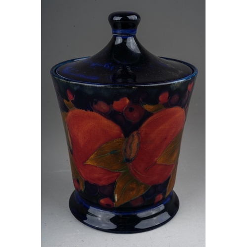 438 - A William Moorcroft Pomegranate pattern conical vase & cover, dark blue ground, green painted signat... 