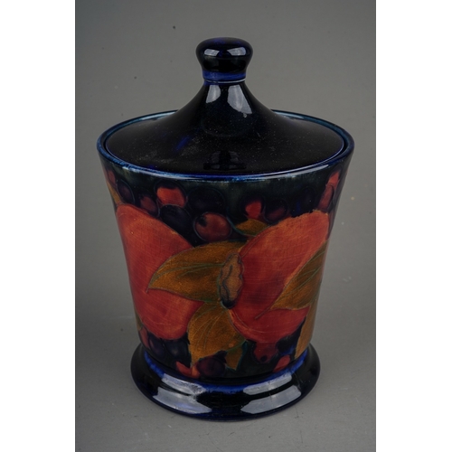 438 - A William Moorcroft Pomegranate pattern conical vase & cover, dark blue ground, green painted signat... 