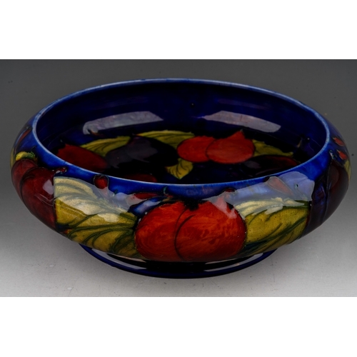 439 - A William Moorcroft shallow bowl in the Wisteria pattern on a shallow bowl with inverted rim, blue s... 