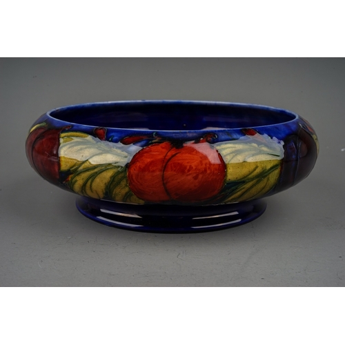 439 - A William Moorcroft shallow bowl in the Wisteria pattern on a shallow bowl with inverted rim, blue s... 