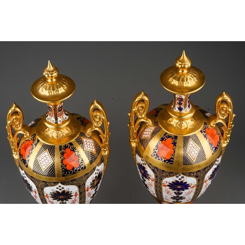 483 - A pair of Royal Crown Derby Imari 1128 solid gold band twin handled urns and covers, the three secti... 