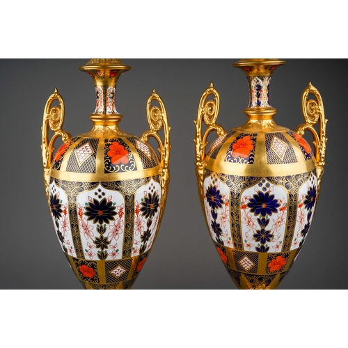 483 - A pair of Royal Crown Derby Imari 1128 solid gold band twin handled urns and covers, the three secti... 