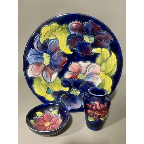 486 - A Moorcroft pottery Clematis pattern platter, dark blue ground, impressed and painted signature mark... 