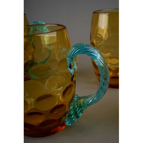 511 - A set of five 20th century dimpled amber glass tankards with twisted blue glass handles, height 10cm... 