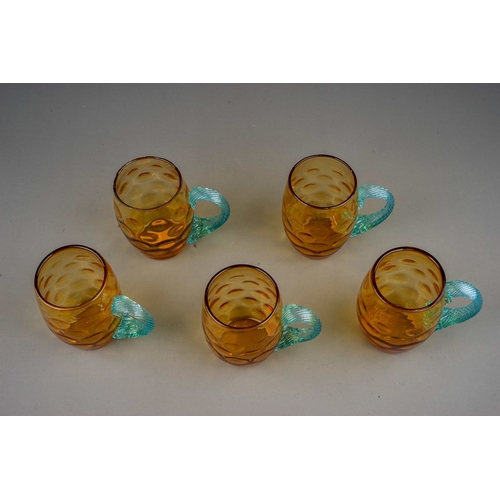 511 - A set of five 20th century dimpled amber glass tankards with twisted blue glass handles, height 10cm... 