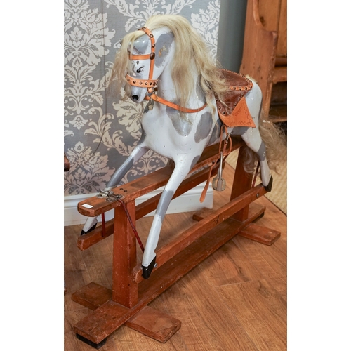 650 - A Victorian style small rocking horse on trestle base, the dapple grey horse complete with bridle an... 