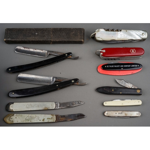 702 - A tin containing a small collection of pocket knives and cut throat razors, including a hallmarked s... 