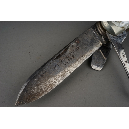 702 - A tin containing a small collection of pocket knives and cut throat razors, including a hallmarked s... 