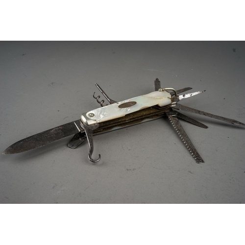 702 - A tin containing a small collection of pocket knives and cut throat razors, including a hallmarked s... 