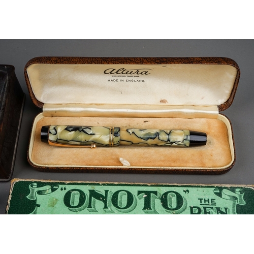 703 - A tin containing a collection of fountain pens, including cased Altura with 14k nib, a brown pen wit... 