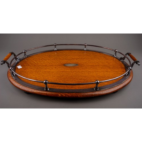 734 - A late 19th century oak and silver plated oval twin handled tray with open gallery, bears oval prese... 