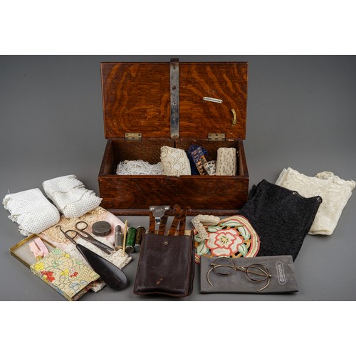 735 - An oak box containing a collection of textiles, sewing requisites, etc, including two needle dispens... 