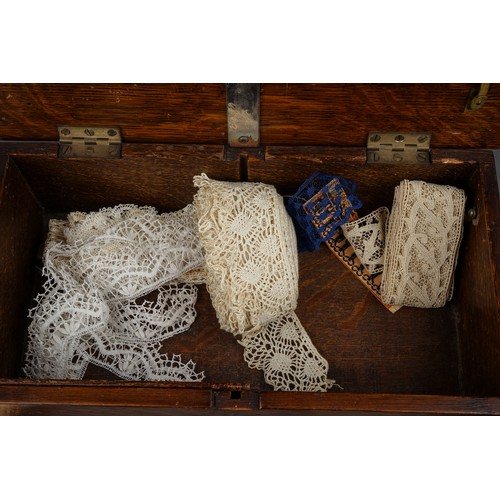 735 - An oak box containing a collection of textiles, sewing requisites, etc, including two needle dispens... 