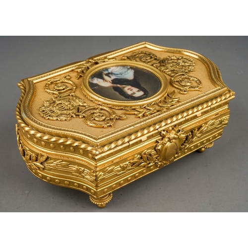 769 - A mid 20th century French gilt metal jewellery box of shaped rectangular form, the hinged cover with... 