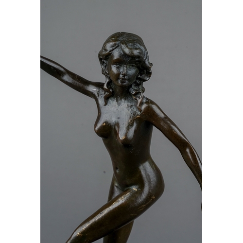 773 - A reproduction Art Deco style bronze of a female nude dancer, mounted on a circular black slate base... 