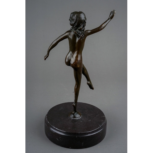 773 - A reproduction Art Deco style bronze of a female nude dancer, mounted on a circular black slate base... 