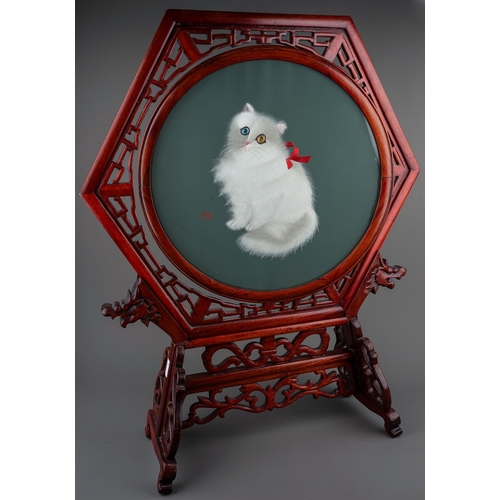 774 - A second half 20th century Chinese hexagonal table screen of a textile cat, the circular centre pivo... 