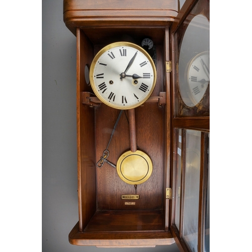 843 - An early 20th Century German mahogany cased H.A.C (Wurttemberg) wall clock with pendulum, glazed sin... 