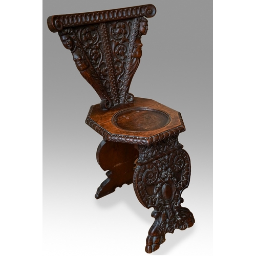 852 - A late 19th / early 20th century carved oak Italian Sgabello hall chair, profusely carved with carya... 