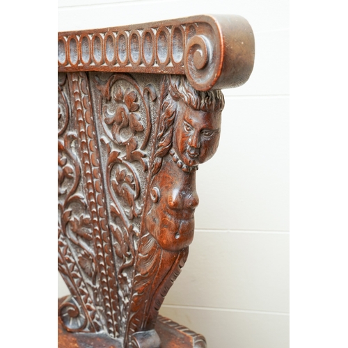 852 - A late 19th / early 20th century carved oak Italian Sgabello hall chair, profusely carved with carya... 