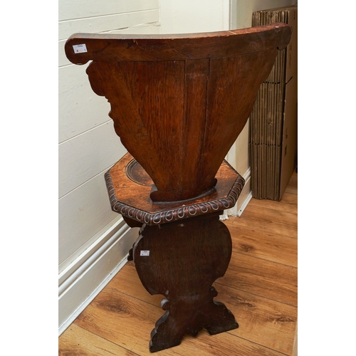 852 - A late 19th / early 20th century carved oak Italian Sgabello hall chair, profusely carved with carya... 