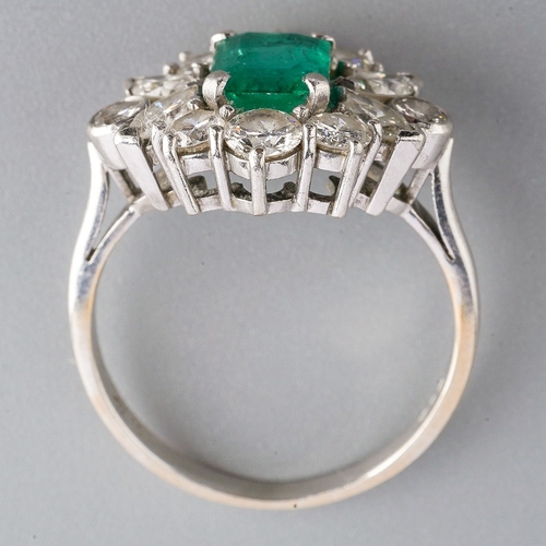 15 - A platinum emerald and diamond cluster ring, set with an emerald-cut emerald approx 7.00mm x 5.35mm ... 