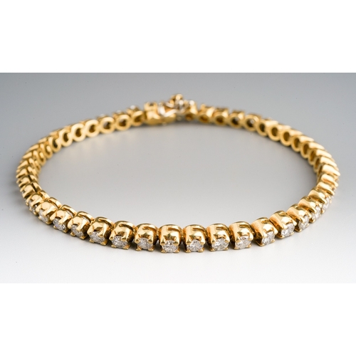 17 - An 18ct yellow gold and diamond line bracelet, set with forty-six round brilliant-cut diamonds, esti... 