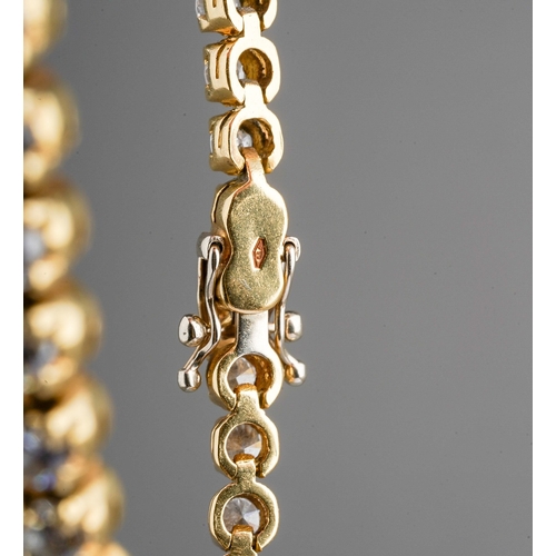 17 - An 18ct yellow gold and diamond line bracelet, set with forty-six round brilliant-cut diamonds, esti... 