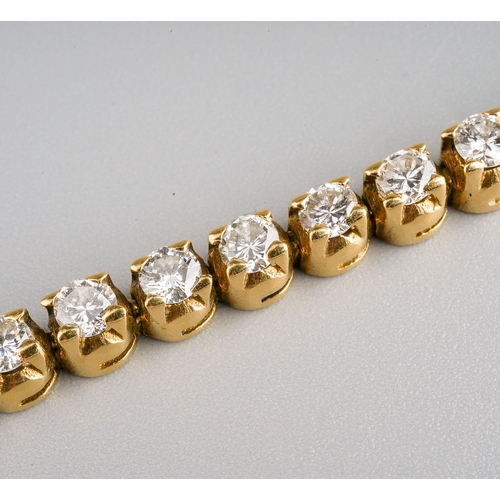 17 - An 18ct yellow gold and diamond line bracelet, set with forty-six round brilliant-cut diamonds, esti... 