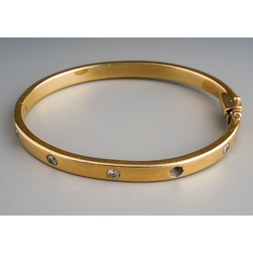 18 - A yellow gold and diamond hinged bangle set with four round brilliant-cut diamonds (one missing), es... 