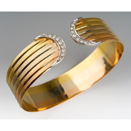 19 - An 18ct tri-colour gold and diamond torque bangle, grooved decoration with crescent terminals, each ... 