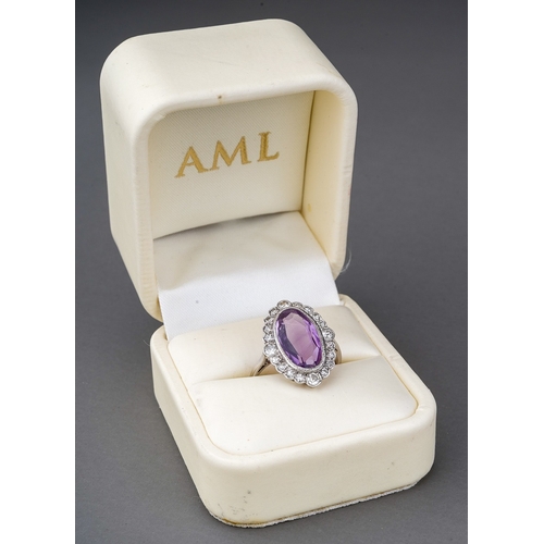 23 - An amethyst and diamond cluster ring, set with an oval shape amethyst, within a single and early bri... 