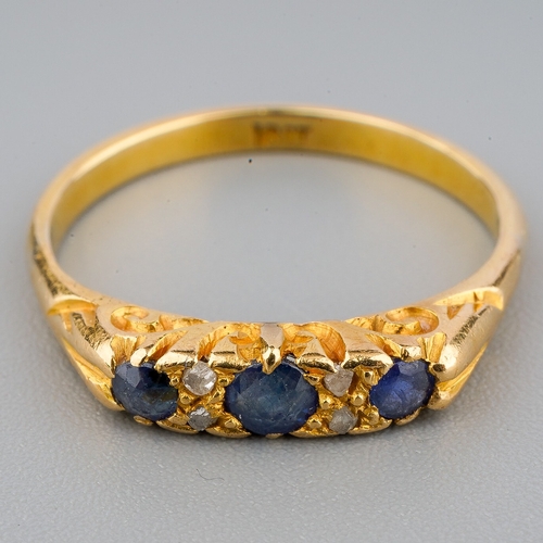 33 - An 18ct gold sapphire and diamond ring, three round cut sapphires with diamond chip spacers, size N,... 