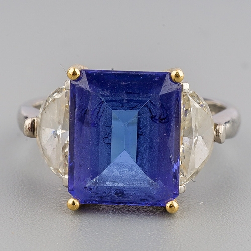 40 - A tanzanite and diamond three stone ring, set with a principal tanzanite and two half moon cut diamo... 