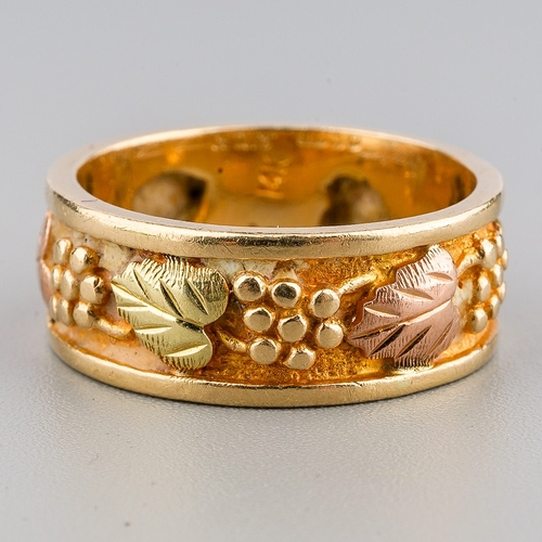 43 - A 14K yellow and rose gold ring, with a band of fruiting vine, size M, gross weight approx 5.4g