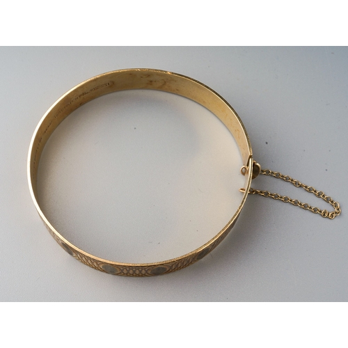 74 - 9ct gold bangle with etched detail and safety chain. Gross weight 20.8g