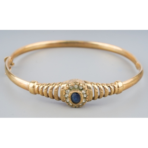 111 - A 9ct gold sapphire bangle, set with blue and colourless sapphires, stamped 375, approximate gross w... 