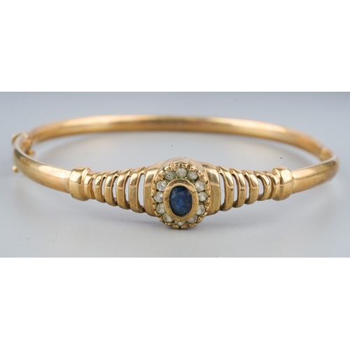 111 - A 9ct gold sapphire bangle, set with blue and colourless sapphires, stamped 375, approximate gross w... 