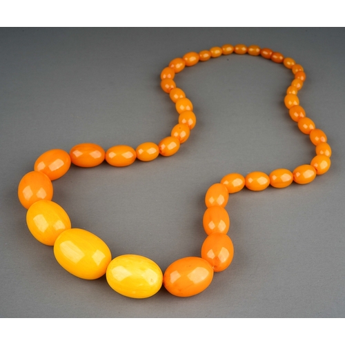 130 - Amber bead necklace with a string of graduated butterscotch polished oval amber beads, measuring app... 