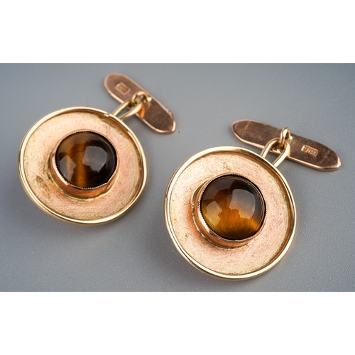 142 - Pair of yellow metal tiger's eye cufflinks. Each set with a circular tiger's eye cabochon each measu... 