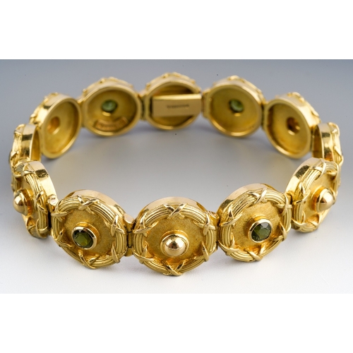 152 - A Theo Fennell 18ct gold bracelet, designed as a series of circular links, six links set with green ... 