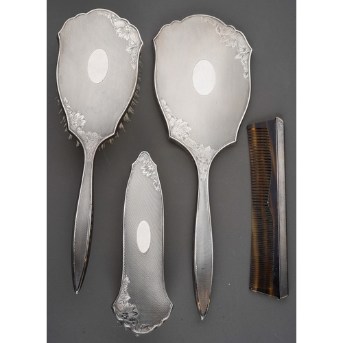 255 - An Elizabeth II cased silver four piece dressing table set, comprising hand mirror, two brushes and ... 