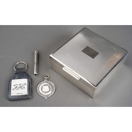 262 - An Elizabeth II silver cigarette box of square form, engine turned cover, vacant cartouche, cedarwoo... 