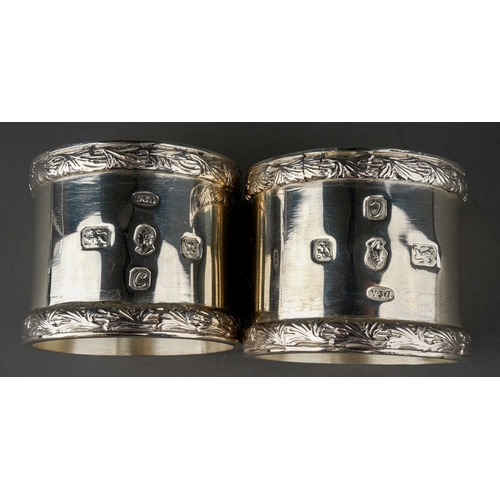 297 - A pair of Elizabeth II silver large napkin rings with raised foliate borders, hallmarked by Derby Co... 