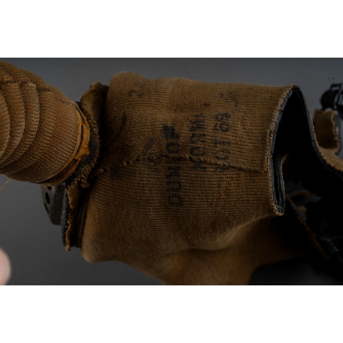 397 - A WW II gas mask, with painted red canister stamped 1940, with fabric covered face mask and tubing, ... 