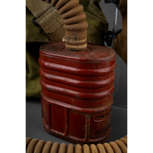 397 - A WW II gas mask, with painted red canister stamped 1940, with fabric covered face mask and tubing, ... 