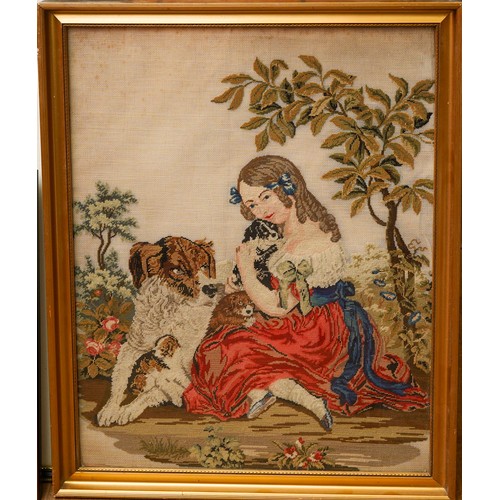 484 - A Victorian needlework panel of a young girl with three dogs, she holds a puppy, foliage behind, app... 