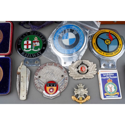 504 - A group of vintage collectables including badges, chrome and enamel car badges, medallions in fitted... 