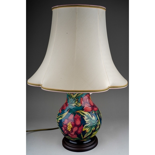 608 - A Moorcroft pottery baluster shaped table lamp in the Peony design by Philip Gibson, mounted on a wo... 