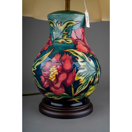 608 - A Moorcroft pottery baluster shaped table lamp in the Peony design by Philip Gibson, mounted on a wo... 